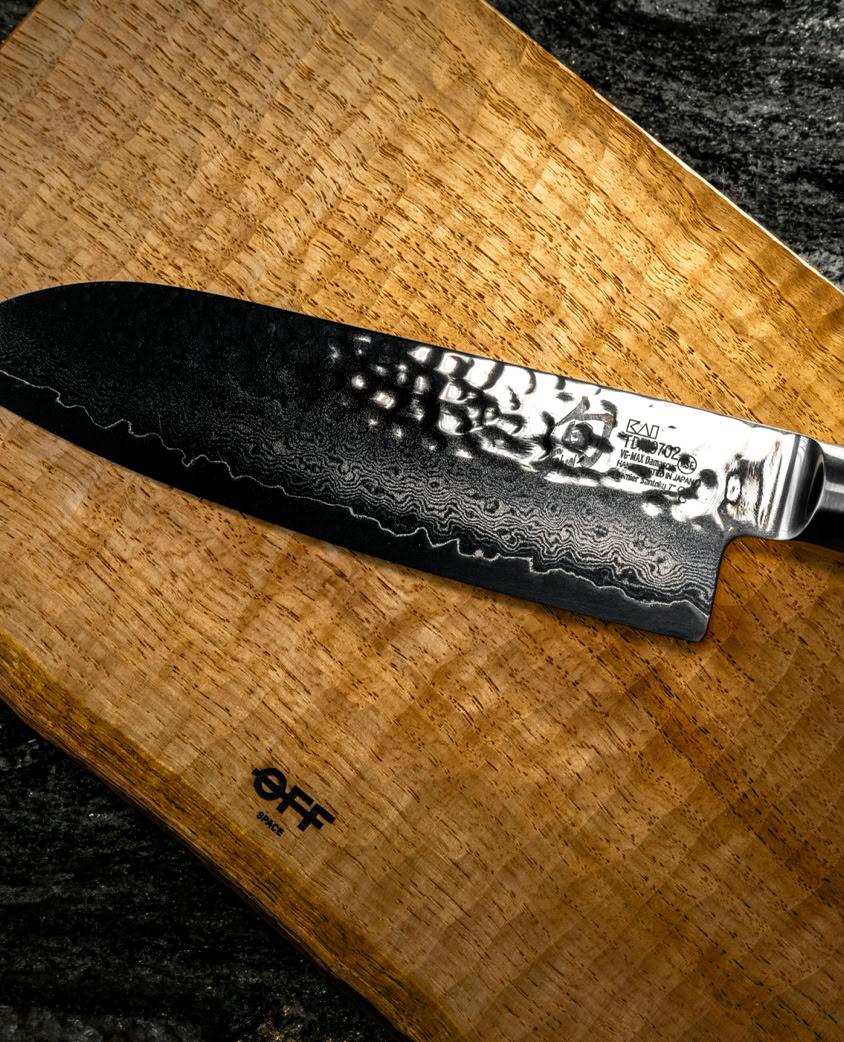 High-quality Santoku knife displayed on a textured wooden board, ideal for culinary settings.